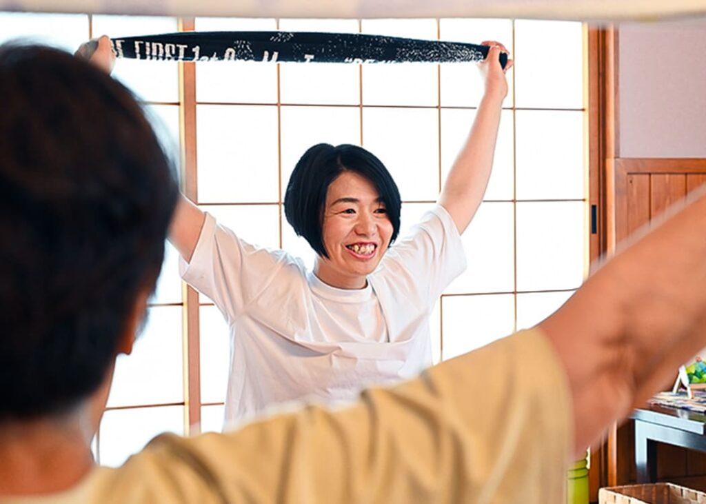 両腕でタオルを持ち背中を伸ばすストレッチ